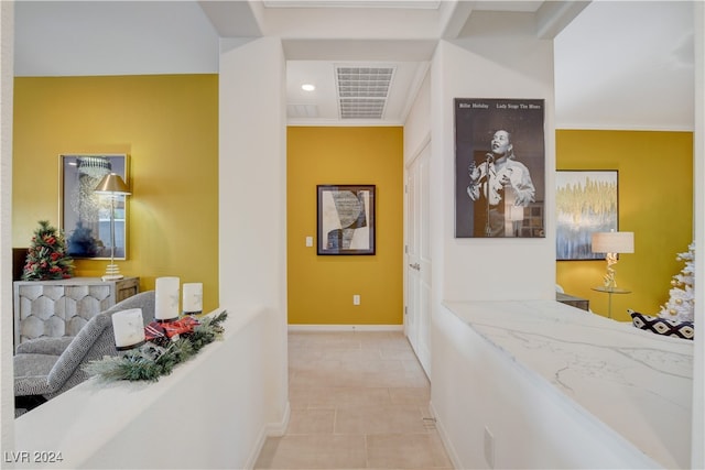 hall with light tile patterned floors and crown molding