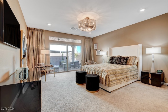 carpeted bedroom featuring access to outside and a notable chandelier