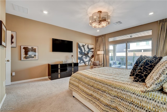 carpeted bedroom featuring access to exterior and an inviting chandelier