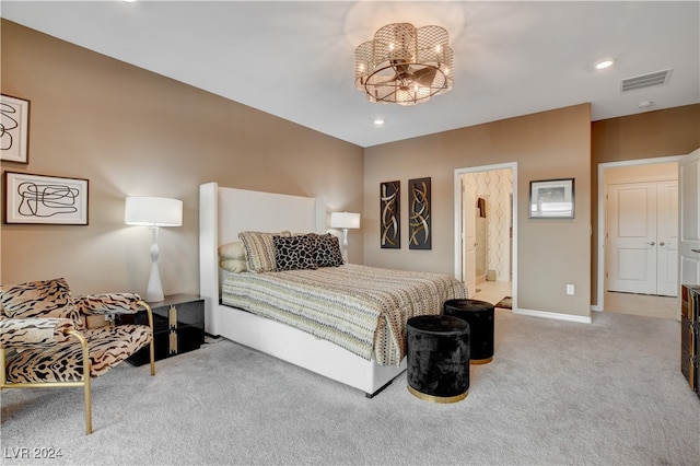 bedroom with light colored carpet, an inviting chandelier, and ensuite bathroom