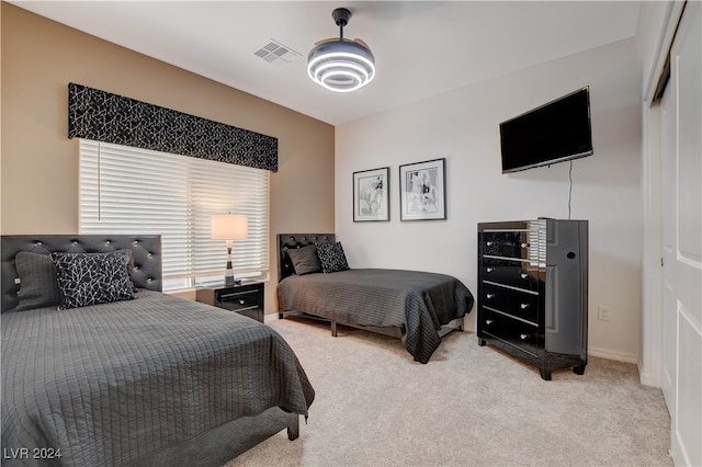 bedroom featuring light colored carpet and a closet