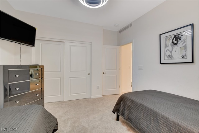 bedroom featuring a closet and light colored carpet