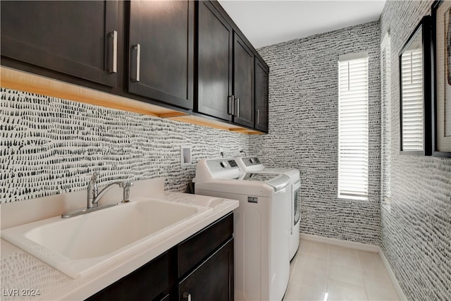 washroom featuring separate washer and dryer, sink, light tile patterned floors, and cabinets