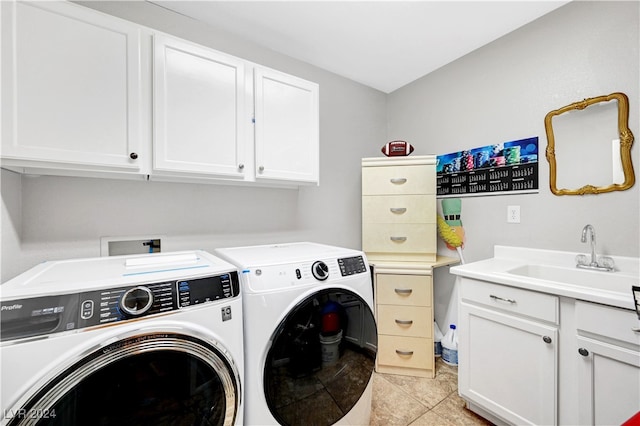 laundry area featuring washing machine and clothes dryer, sink, light tile patterned floors, and cabinets