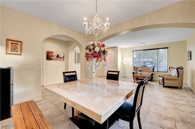 tiled dining room with an inviting chandelier