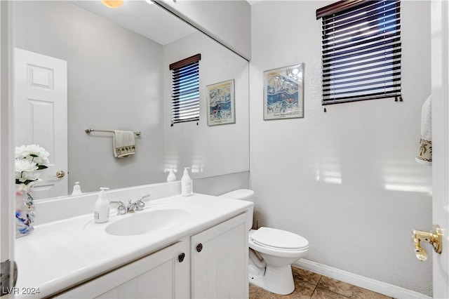 bathroom with tile patterned flooring, vanity, and toilet