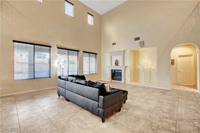 living room featuring light tile patterned floors, a high ceiling, and a wealth of natural light