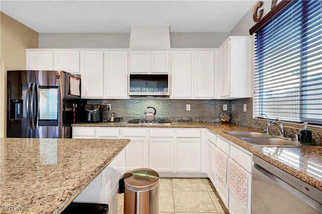 kitchen with light stone countertops, sink, stainless steel appliances, tasteful backsplash, and white cabinets