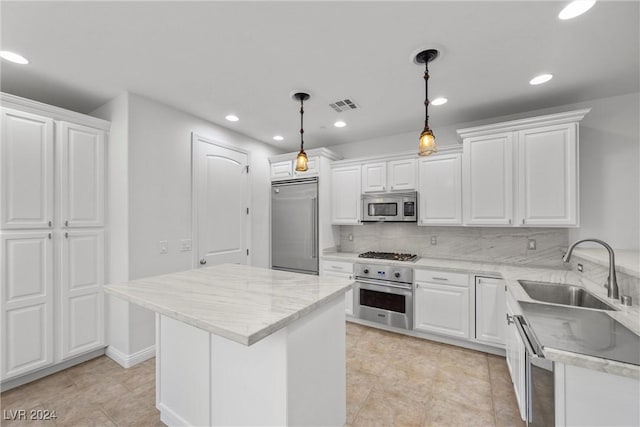 kitchen with pendant lighting, backsplash, white cabinets, sink, and stainless steel appliances