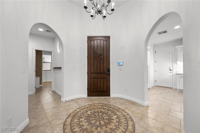 foyer entrance featuring light tile patterned flooring and a notable chandelier