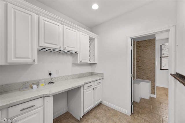 kitchen featuring white cabinets and light stone counters