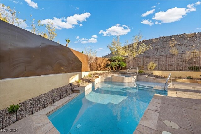 view of swimming pool featuring an in ground hot tub