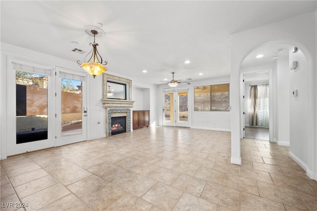 unfurnished living room featuring ceiling fan and a wealth of natural light