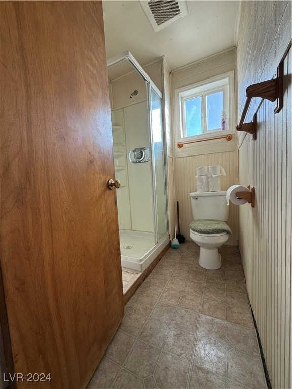 bathroom featuring wood walls, an enclosed shower, and toilet