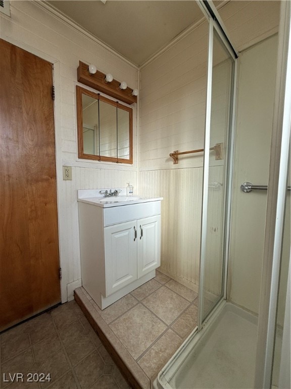 bathroom with ornamental molding, vanity, and a shower with shower door