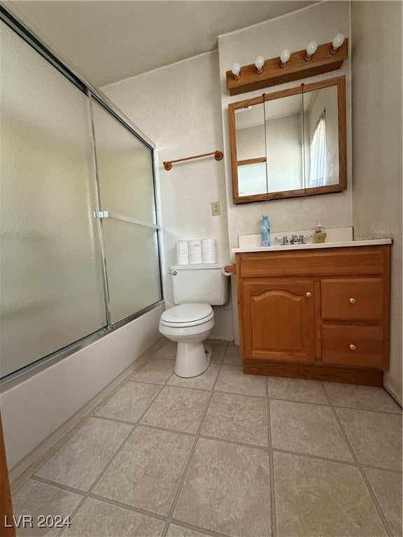 full bathroom featuring tile patterned floors, vanity, bath / shower combo with glass door, and toilet