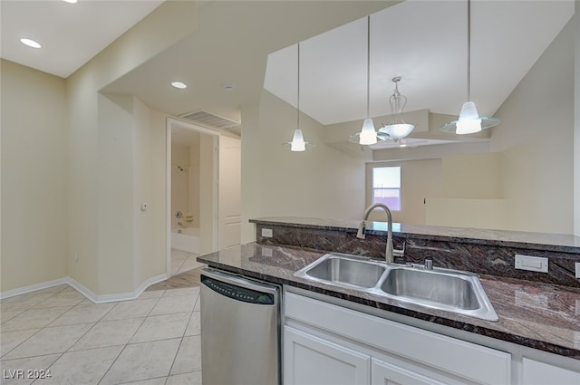 kitchen featuring sink, dark stone countertops, stainless steel dishwasher, pendant lighting, and white cabinets