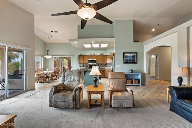 tiled living room featuring a wealth of natural light, high vaulted ceiling, and ceiling fan