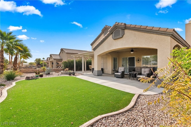 rear view of house featuring a yard, ceiling fan, and a patio area