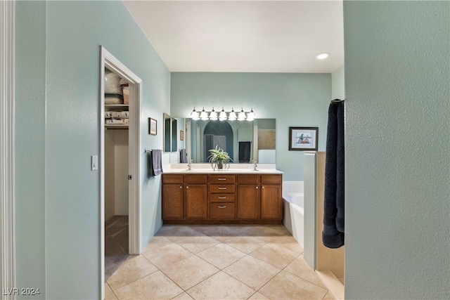 bathroom featuring tile patterned floors, vanity, and a bath