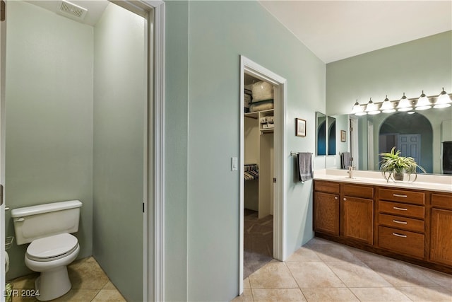 bathroom with toilet, vanity, and tile patterned floors