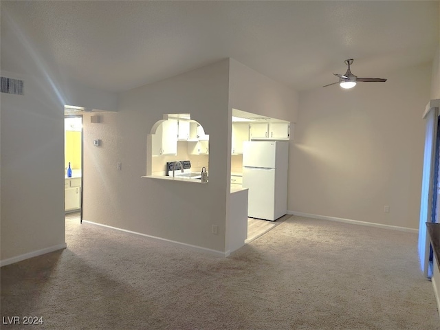 unfurnished living room featuring ceiling fan and light colored carpet