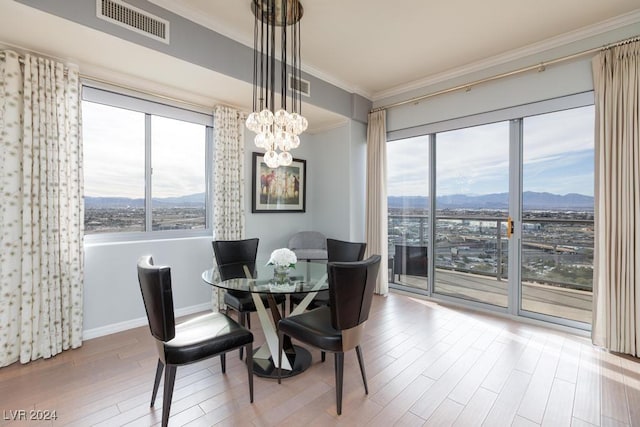 8255 Las Vegas Blvd Unit 2002, Las Vegas, NV 89123 - dining area featuring ornamental molding, a mountain view, a chandelier, wood finished floors, and baseboards