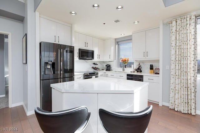 8255 Las Vegas Blvd Unit 2002, Las Vegas, NV 89123 - kitchen with black appliances, wood finished floors, decorative backsplash, baseboards, and recessed lighting