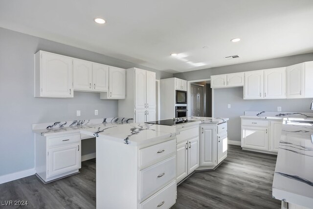 kitchen featuring a center island, light stone counters, dark hardwood / wood-style flooring, and white cabinets