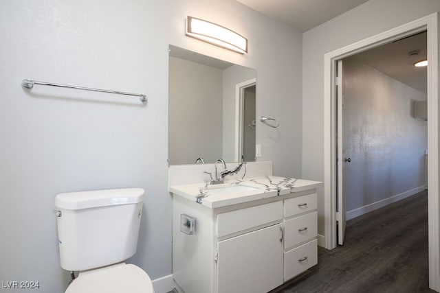 bathroom with toilet, vanity, and hardwood / wood-style flooring