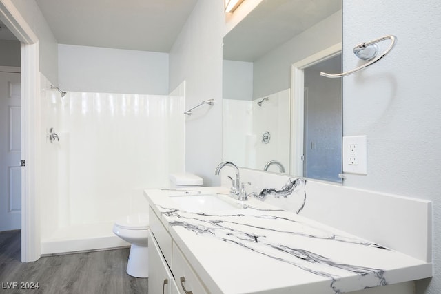 bathroom with hardwood / wood-style flooring, vanity, and a shower