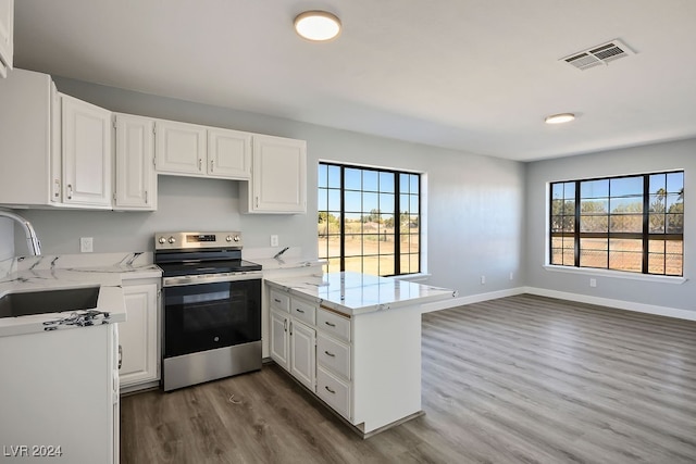 kitchen featuring white cabinetry, dark hardwood / wood-style flooring, electric stove, and kitchen peninsula