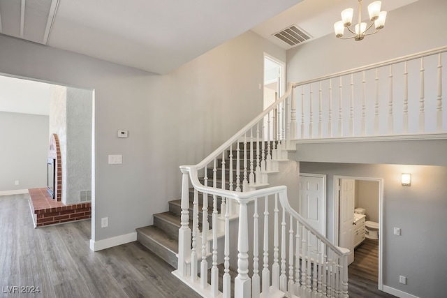 stairway with a chandelier and hardwood / wood-style flooring