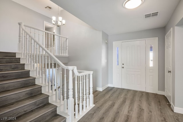 foyer entrance with hardwood / wood-style flooring and an inviting chandelier