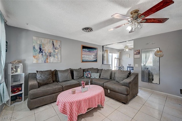 tiled living room with ceiling fan and a textured ceiling