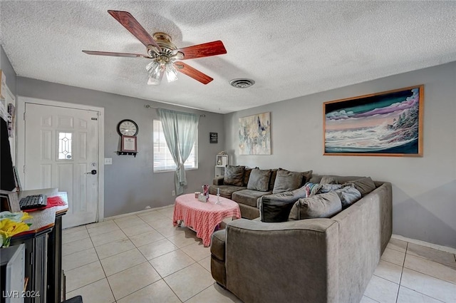 tiled living room with a textured ceiling and ceiling fan