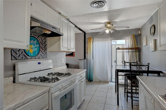 kitchen with ceiling fan, light tile patterned flooring, a textured ceiling, white appliances, and white cabinets