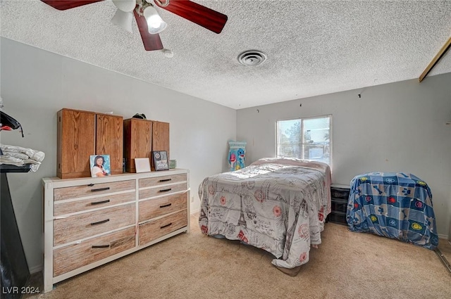 carpeted bedroom featuring a textured ceiling and ceiling fan