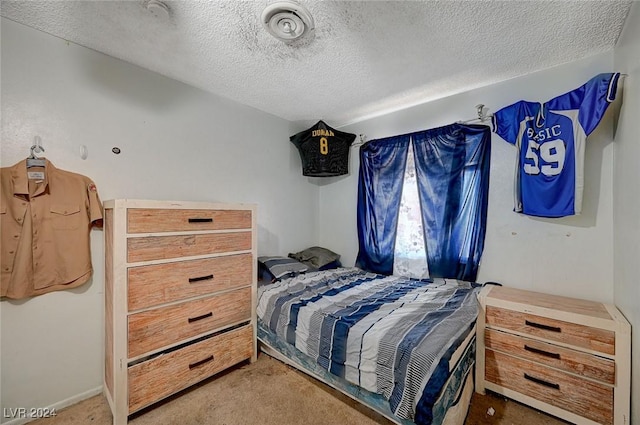 bedroom featuring a textured ceiling and light carpet