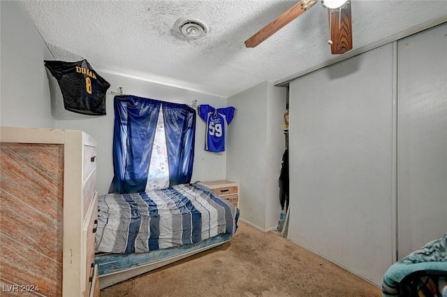 bedroom with carpet, a textured ceiling, and ceiling fan