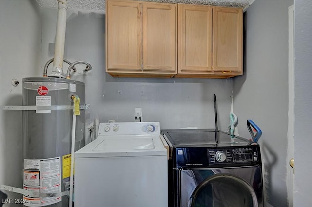 laundry room featuring secured water heater, a textured ceiling, washing machine and dryer, and cabinets