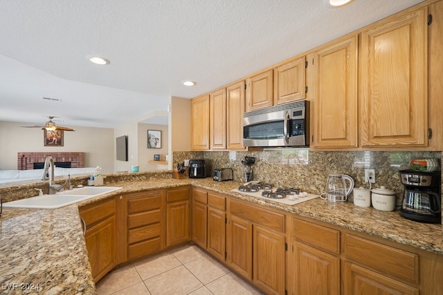 kitchen featuring ceiling fan, sink, white gas cooktop, a textured ceiling, and light tile patterned floors