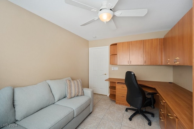 tiled home office featuring built in desk and ceiling fan