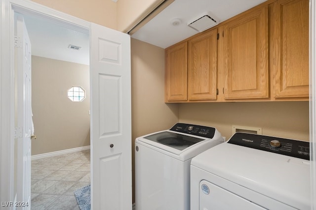 washroom featuring washing machine and dryer and cabinets