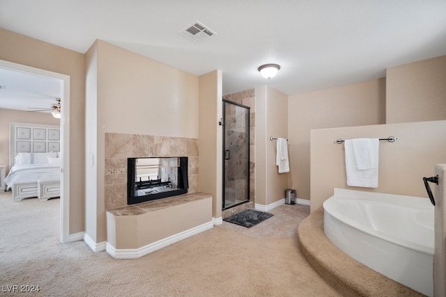 bathroom featuring a tiled fireplace, ceiling fan, and shower with separate bathtub