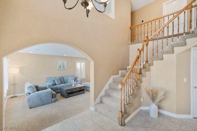 stairs with tile patterned flooring and a notable chandelier