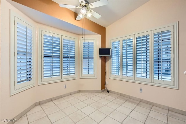 tiled empty room with plenty of natural light, ceiling fan, and lofted ceiling