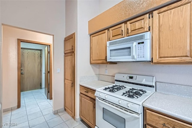 kitchen with light tile patterned floors and white appliances