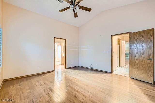 empty room featuring lofted ceiling, ceiling fan, and light wood-type flooring