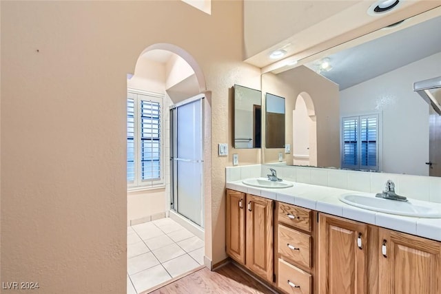 bathroom featuring wood-type flooring, vanity, an enclosed shower, and lofted ceiling